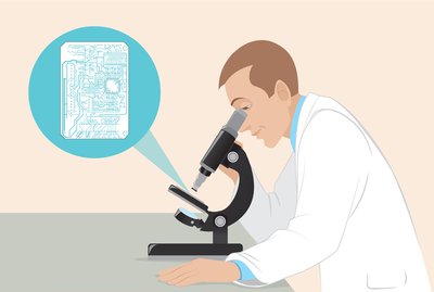 man in lab coat looking at circuit board under a microscope